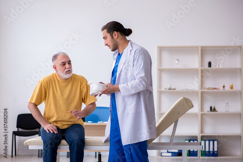 Old neck injured man visiting young male doctor