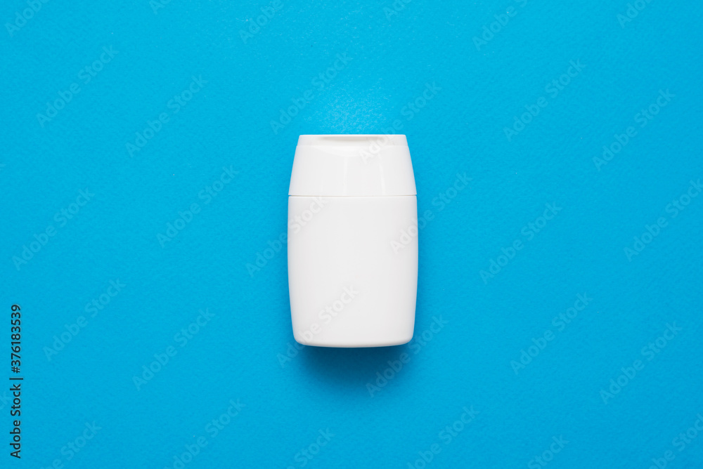 White micellar water bottle on the blue flat lay background.
