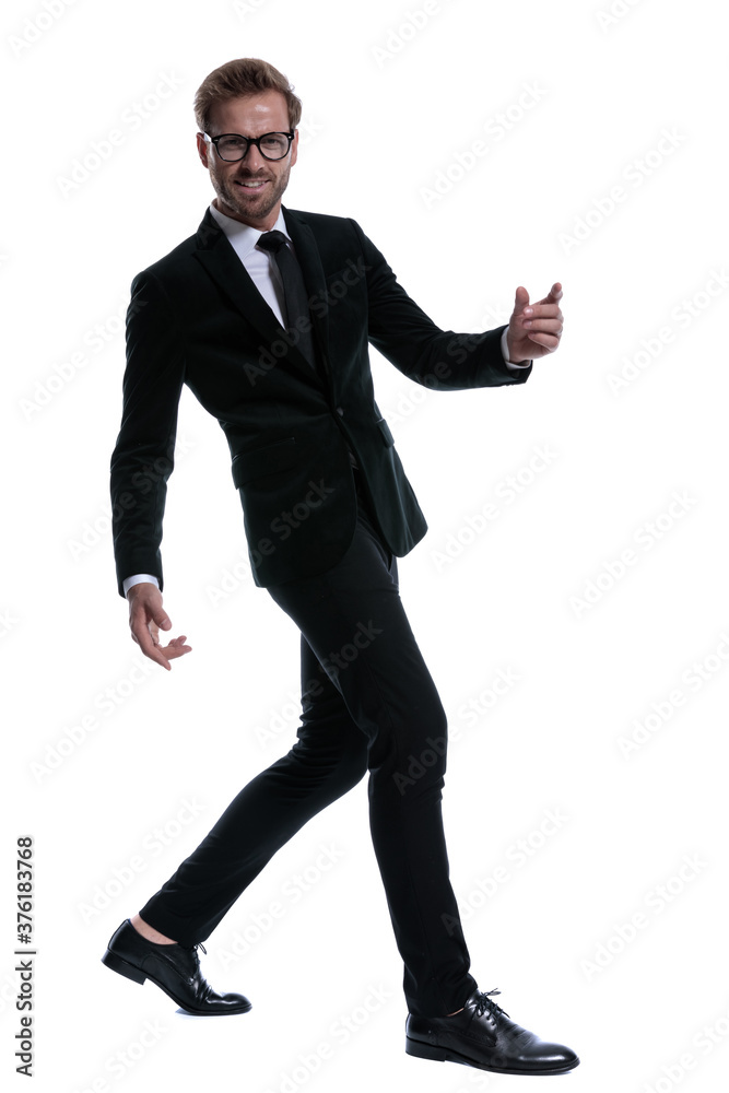 elegant cool man in black suit smiling and walking elegant cool man in black suit smiling and walking