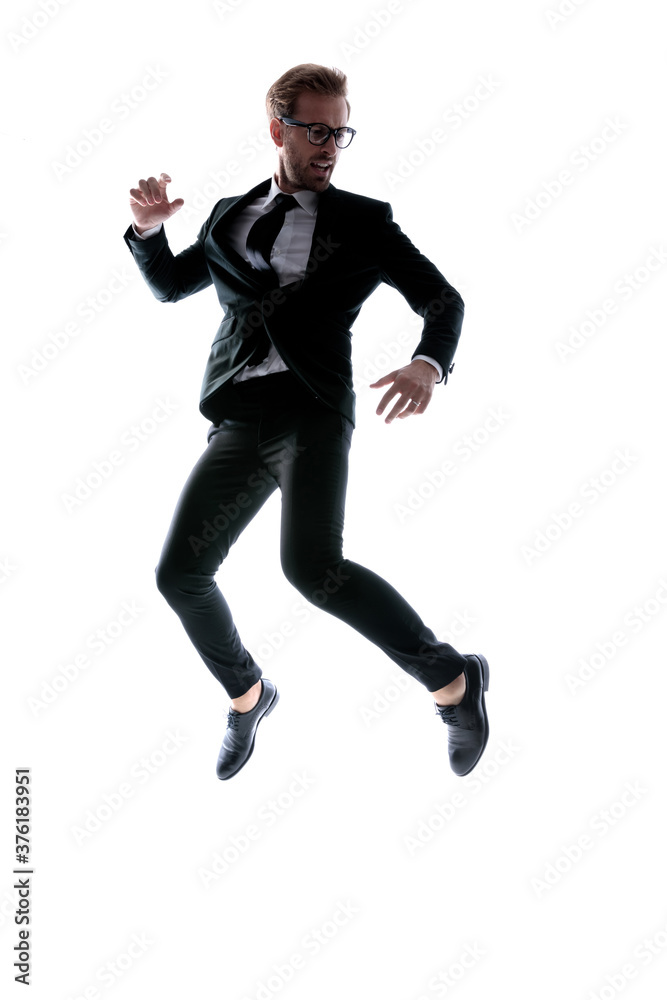 dynamic cool young man in black suit leaping up