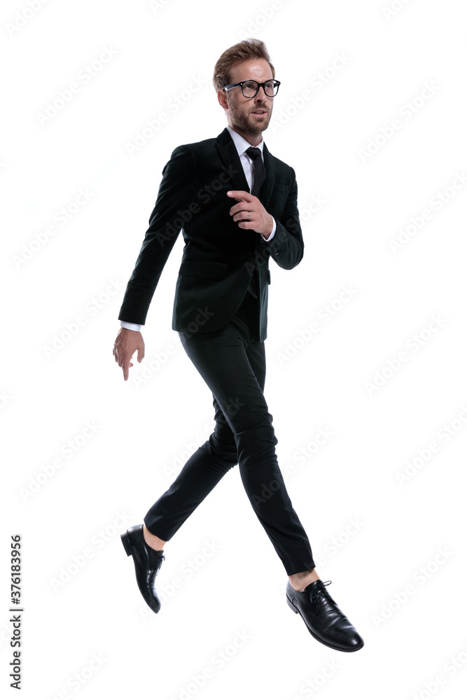 cool elegant man in black suit holding hand in a fashion pose cool elegant man in black suit holding hand in a fashion pose