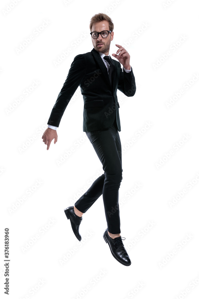 dynamic young man in black suit jumping in the air dynamic young man in black suit jumping in the air