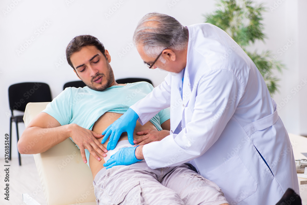 Obraz premium Injured young man visiting experienced male doctor