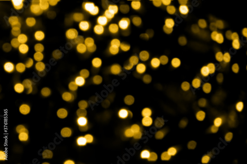 Blurry colored Christmas holiday lights on a black background.