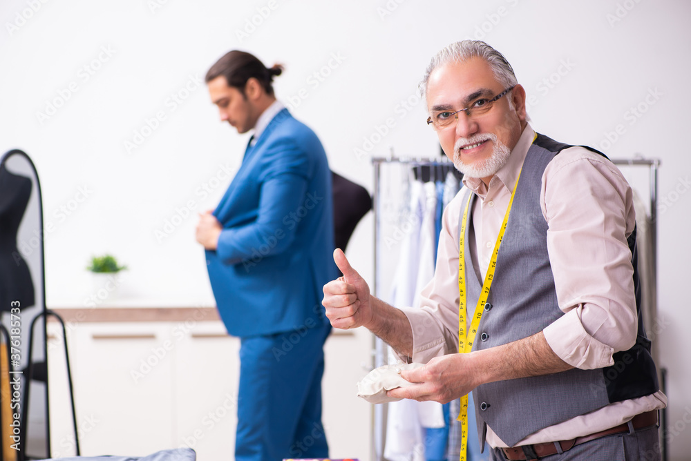 Young businessman visiting old male tailor Young businessman visiting old male tailor