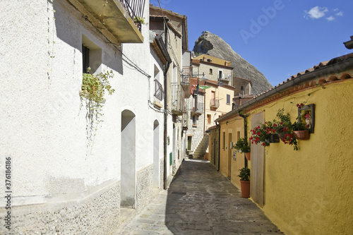 Fototapeta Naklejka Na Ścianę i Meble -  A narrow street among the old houses of Castelmezzano, a rural village in the Basilicata region, Italy.