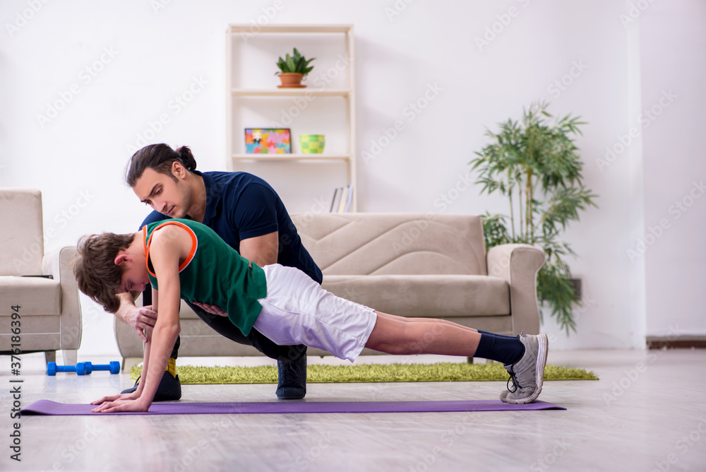 Fototapeta premium Father and son doing sport exercises indoors