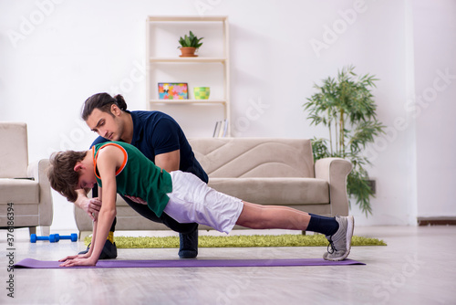 Father and son doing sport exercises indoors