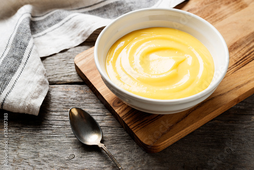 Fototapeta Homemade vanilla custard pudding or lemon curd in a white  bowl.