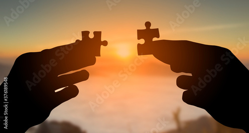 Billede på lærred silhouette of hands holding jigsaw puzzle and raised to joining at sunrise,  Tea
