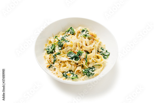 Pasta fettuccine with spinach  in creamy cheese sauce isolated on a white  background.