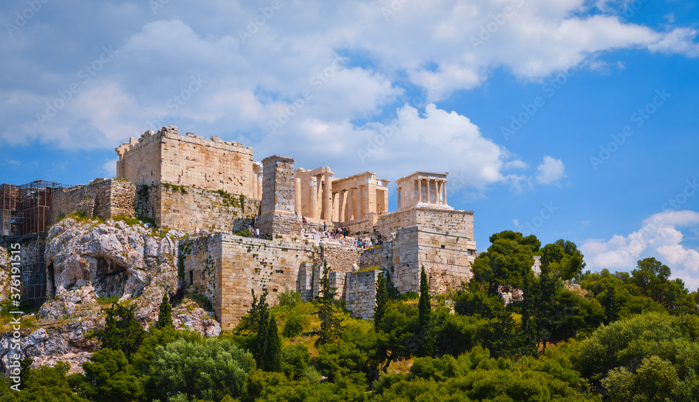 View of Acropolis hill from Areopagus hill on summer day with great clouds in blue sky, Athens, Greece. UNESCO heritage. Propylaea gate, Parthenon.