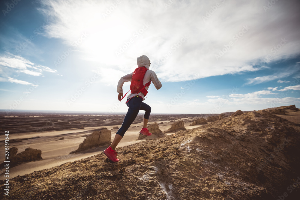 Fitness woman trail runner cross country running on sand desert dunes Fitness woman trail runner cross country running on sand desert dunes