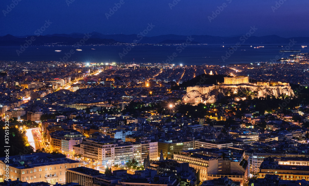 Night view of Athens and Acropolis from Lycabettus hill, Parthenon, Saronic Gulf, Hellenic Parliament. Famous iconic view of UNESCO world heritage.