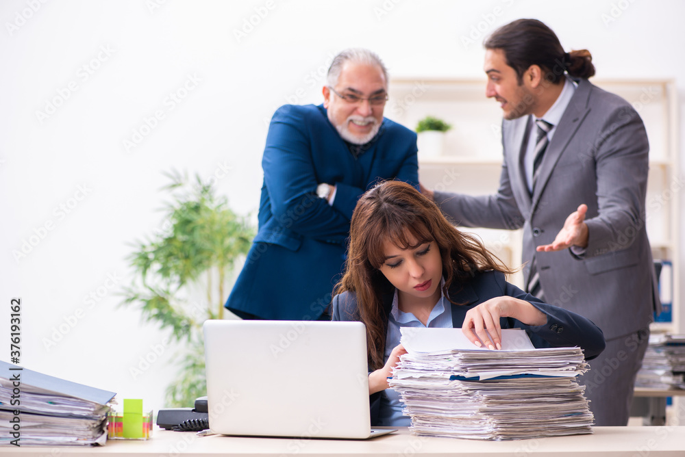 Two male and one female employees working in the office Two male and one female employees working in the office