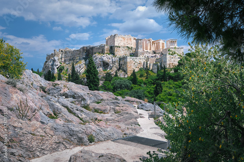 View of Acropolis hill from Areopagus hill on summer day with great clouds in blue sky, Athens, Greece. UNESCO world heritage. Propylaea, Parthenon.