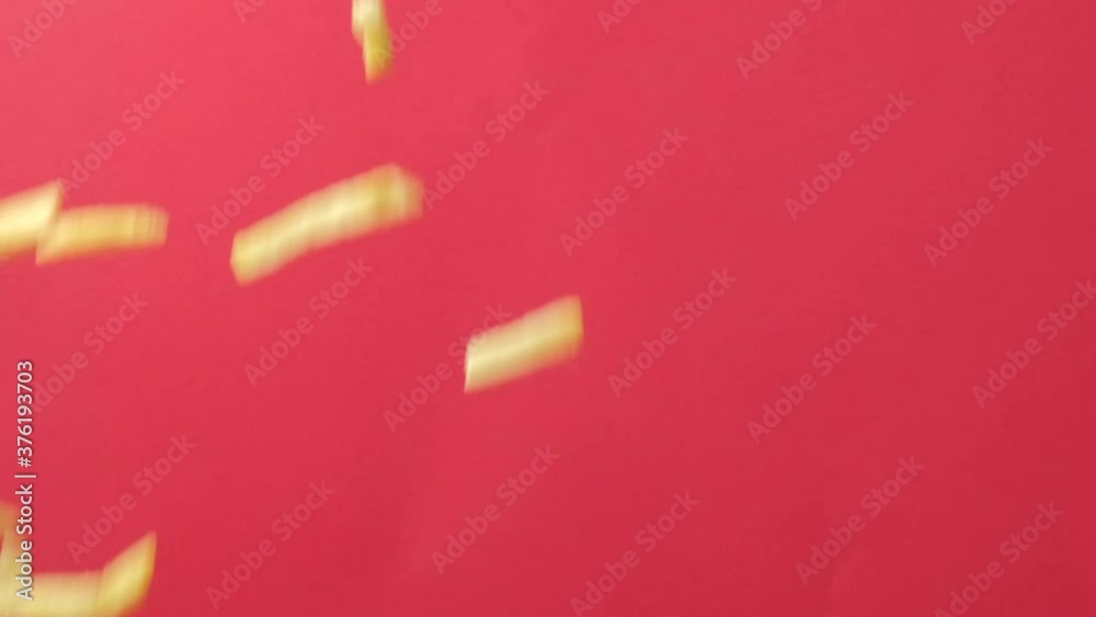 Flying fries in the air on a pink background. Flies from bottom to top