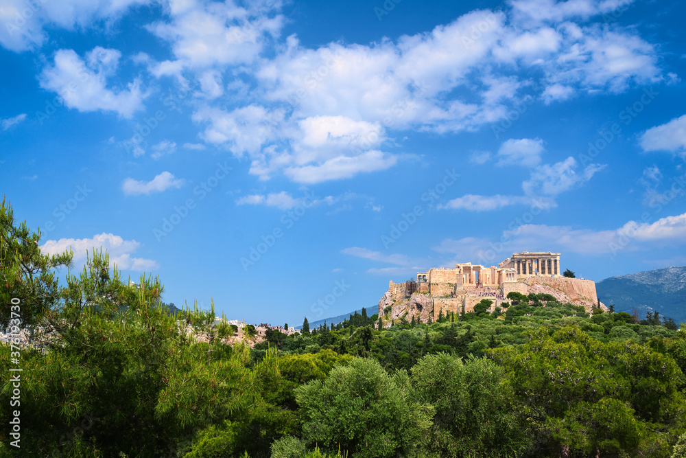 Beautiful view of Acropolis hill in Athens, Greece from Pnyx hill in summer day with great clouds in blue sky. Famous ancient UNESCO heritage site