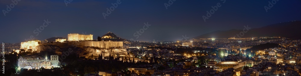 Iconic view of Acropolis hill in Athens, Greece at night. Delicate lights of Parthenon and Odeon theater. UNESCO world heritage. Night panorama.