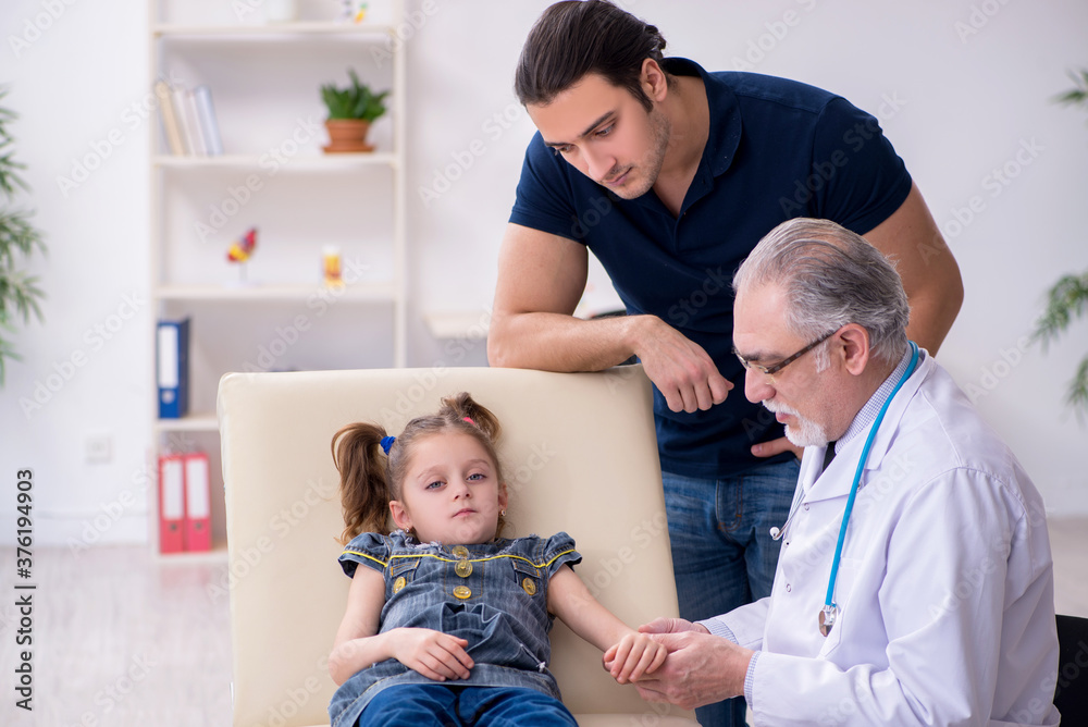 Young father and his daughter visiting old male doctor Young father and his daughter visiting old male doctor