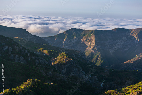 Views of the Sierra Almijara, Tejeda and Alhama from the viewpoint of the highway of the goat, with low clouds that cover the tops of the mountains, creating a panoramic view of a sea of clouds.