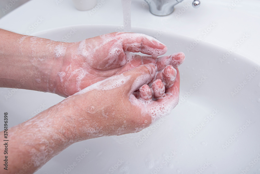 Fototapeta premium Man washing his hands by soap with foam, concept picture about virus and hygiene 