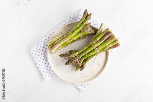 Two bunches of asparagus on white plate