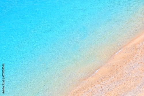 Fototapeta Naklejka Na Ścianę i Meble -  Empty sand beach with transparent sea water. View above. Mediterranean background.