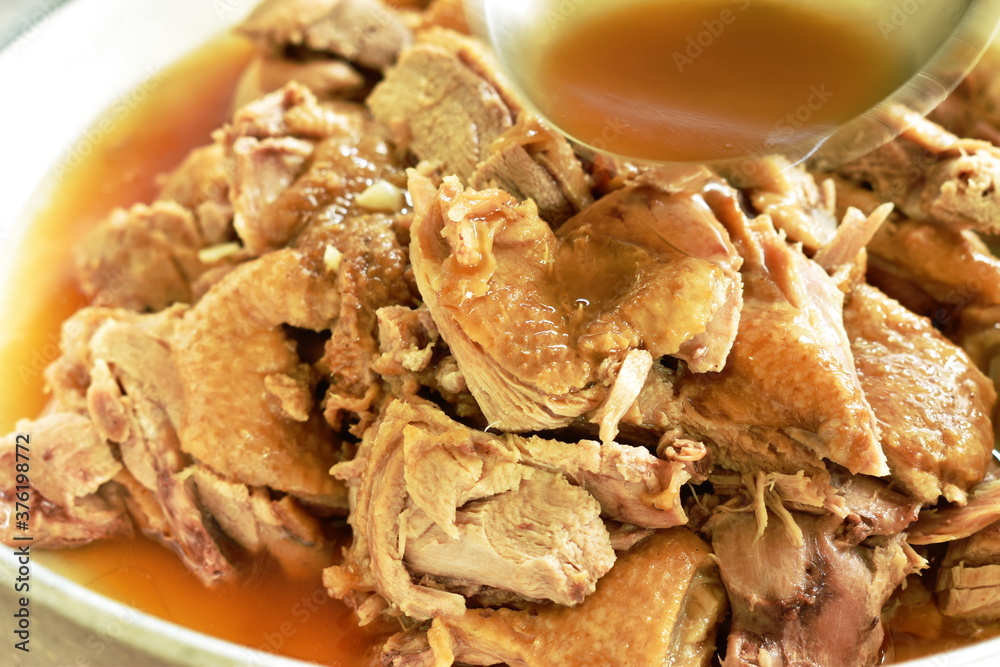 boiled duck in brown soup slice dressing sauce by ladle on plate