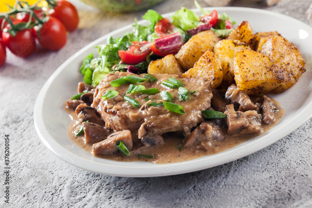 Pork loin chop with mushroom sauce and baked potatoes Pork loin chop with mushroom sauce and baked potatoes