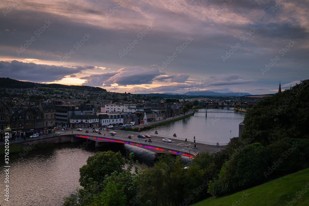 Inverness city landscape with the illumnated city and its reflection in the river Ness, Scotland, United Kingdom