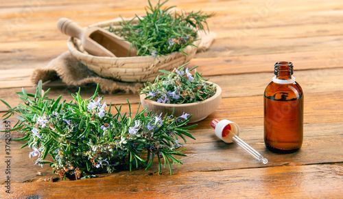 one Bottle of rosemary essential oil on a wooden table
