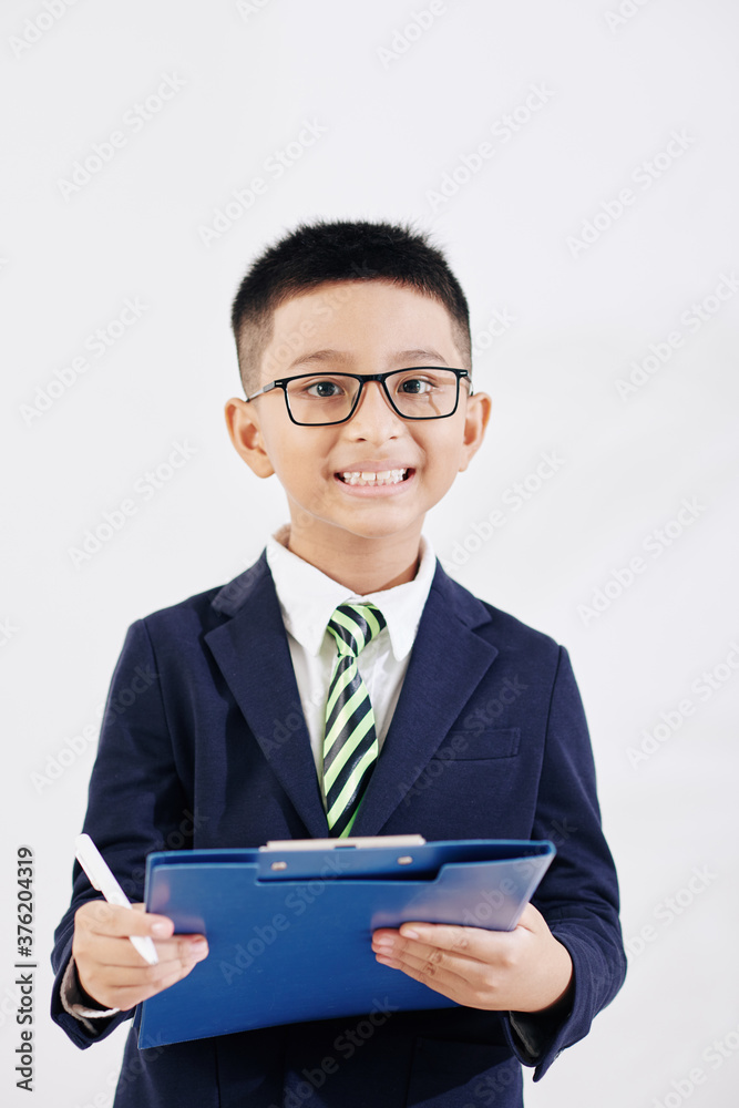 Portarit of joyful smiling Vietnamese kid in formalwear with folder writing in document Portarit of joyful smiling Vietnamese kid in formalwear with folder writing in document