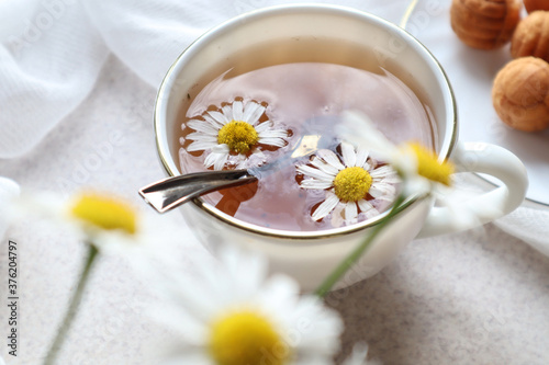 Two daisies in a Cup of chamomile tea  close-up  top view  bokeh-the concept of a good time and a delicious tea party