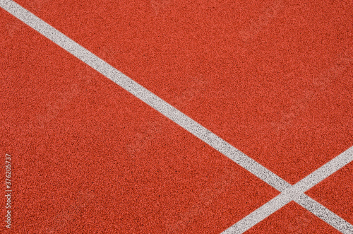 Top view of the running track rubber lanes cover texture with white line marking for background.