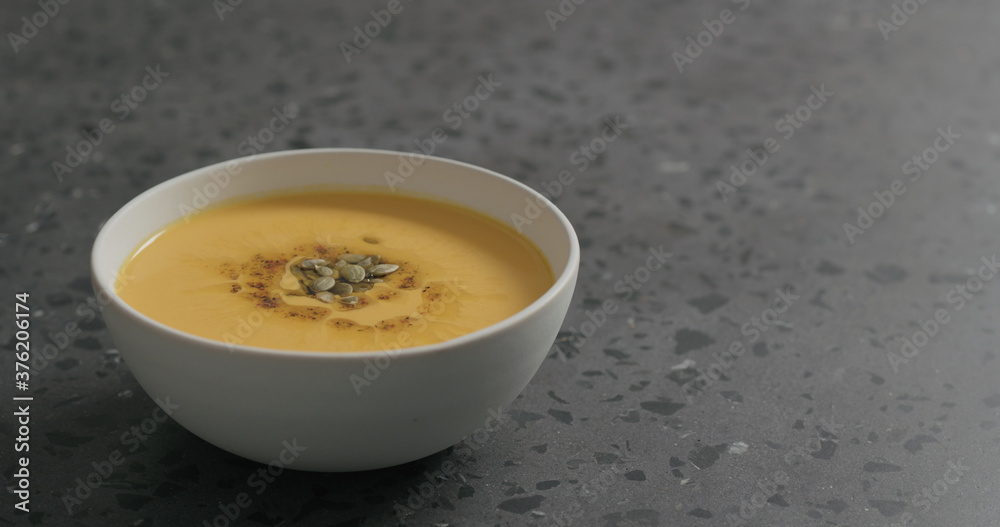 pumpkin cream soup in white bowl on terrazzo countertop pumpkin cream soup in white bowl on terrazzo countertop