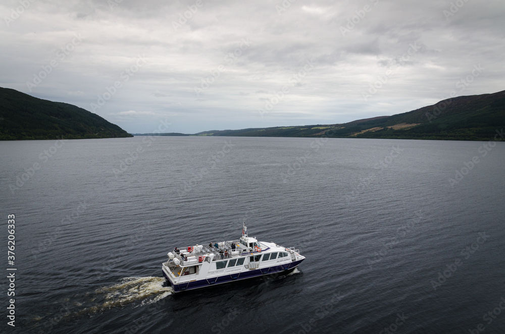 Tourist boat on the famous Loch Ness on a cloudy day, HIghland, Scotland