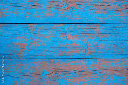 wooden textured vintage background of old wood wide boards. Peeling paint on an old blue and red wooden floor.