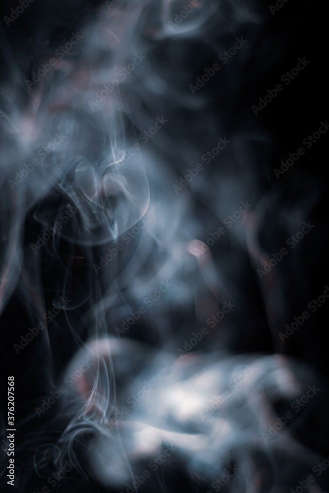 White smoke from incense stick isolated against dark background