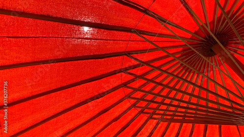 Fototapeta Naklejka Na Ścianę i Meble -  Low angle view of red parasols in sunlight