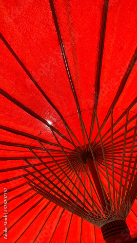 Low angle view of red parasols in sunlight