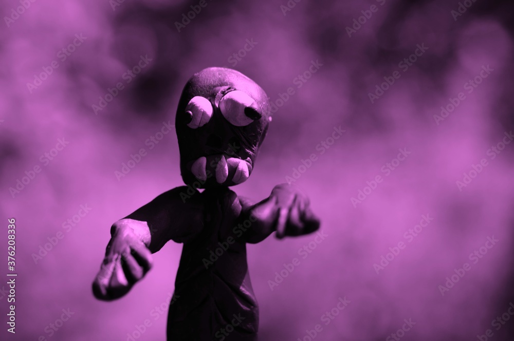 Figure of a zombie made of plasticine on a colored background.