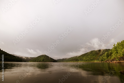 Mirror smooth water of the carpathian Zetelaka lake. Beautyful landscape after rain