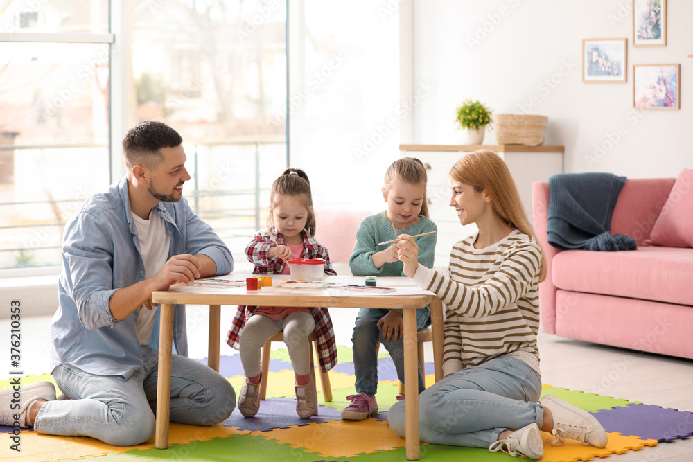 Lovely family painting at table indoors. Playing with children Lovely family painting at table indoors. Playing with children