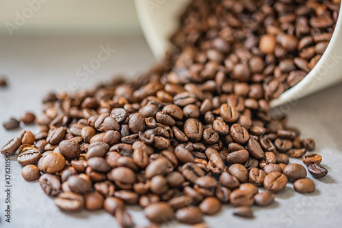 Geröstete Kaffee Bohnen fallen aus einer weißen Dose 