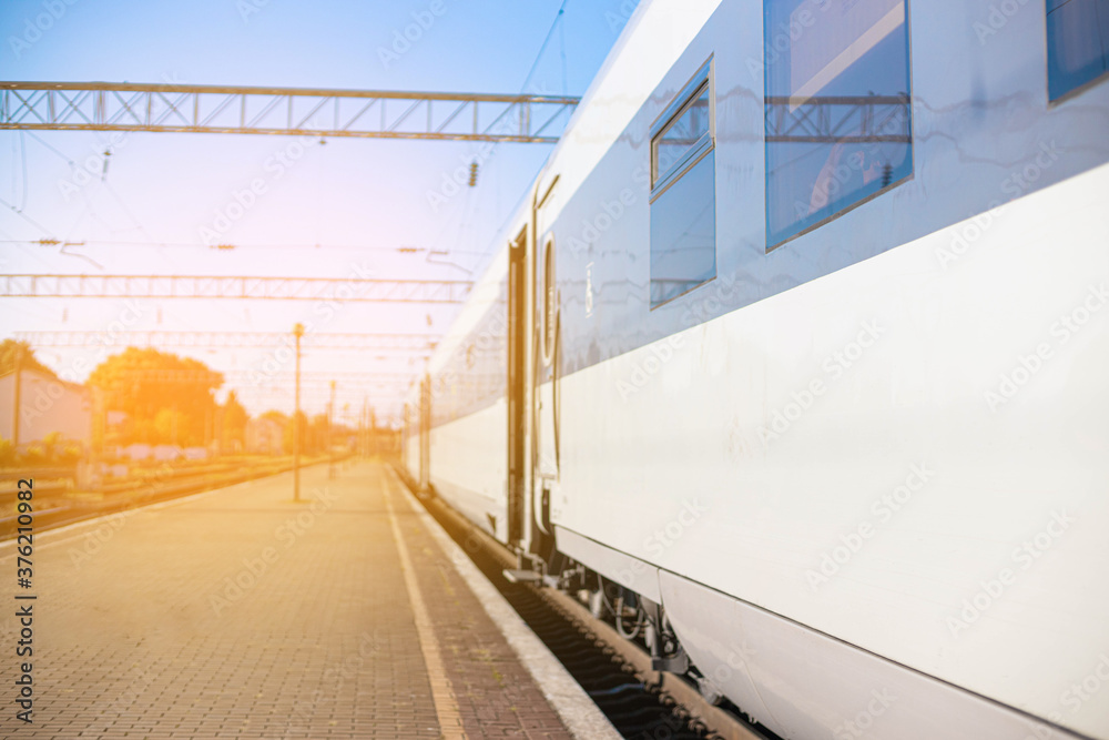 High-speed train on rails on the railway station platform on a sunny day. Modern intercity train on railway platform. Travel concept High-speed train on rails on the railway station platform on a sunny day. Modern intercity train on railway platform. Travel concept