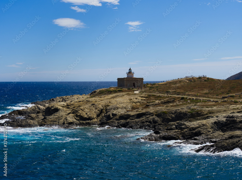 lighthouse in costa brava with blue sky and waves