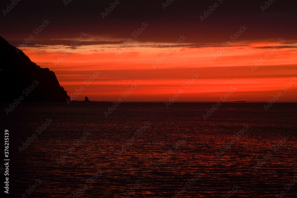 scarlet dawn rises over the sea