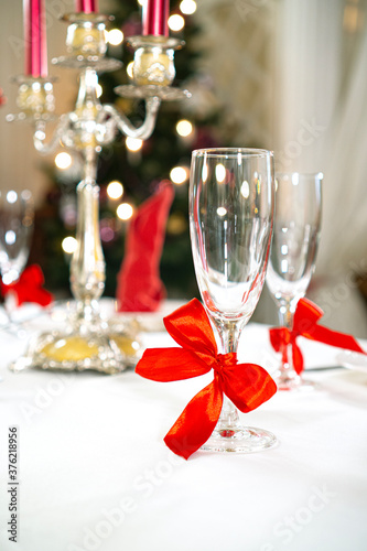 Beautiful holiday table setting for Christmas celebration. Christmas decorated fir tree on a backdrop. Vertical background.