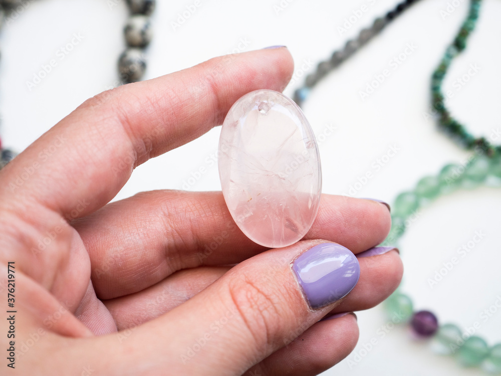 Pendant made of natural rose quartz in a woman's hand Pendant made of natural rose quartz in a woman's hand